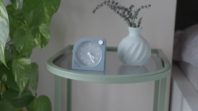Clock and vase on a bedside table in a simple room