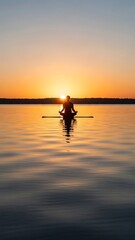 Serene Paddleboarder on Calm Water at Sunset.