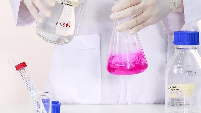 Scientist Swirling Pink Liquid in Erlenmeyer Flask During Chemistry Experiment