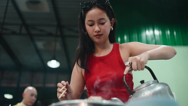 Asian woman cooking thai barbecue moo krata