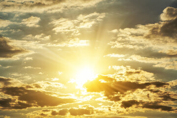 Beautiful golden sunset sky with dramatic sun rays breaking through clouds. A divine background symbolizing hope, spiritual worship, God's light, and the freedom of soul.