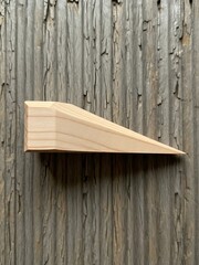 Woodworking Wedge on Textured Surface with Grain Details and Light Tones