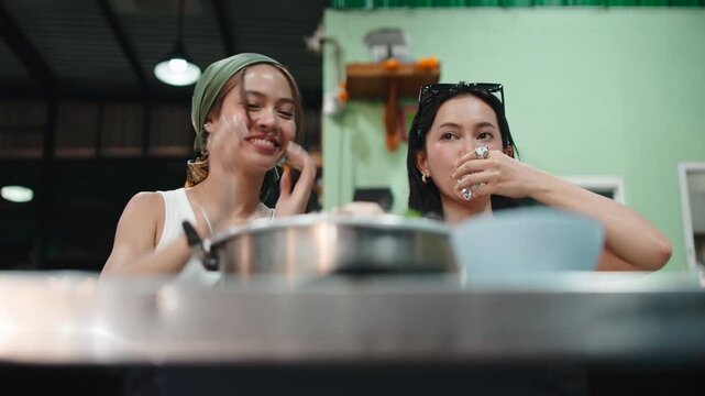 Asian women friends having fun eating thai barbecue