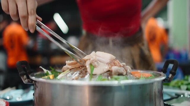 Woman cooking thai barbecue pork moo kra ta