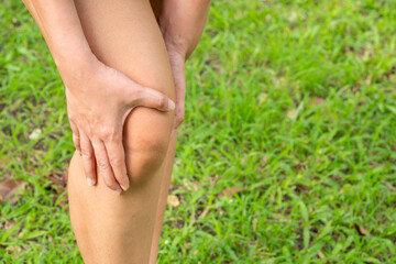 Woman with knee pain, he puts his hand on his knee, pain point from osteoarthritis and osteoarthritis, medical concept and treatment	