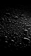 High-contrast macro photo of sparkling water droplets scattered across a solid black background. Moody minimalist texture ideal for elegant overlays and abstract designs