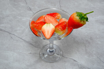 Strawberry martini cocktail with ice cubes on a glass closeup shot marble floor closeup view with copy space 