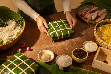 Traditional Vietnamese Chung cake wrapping process with dong leaves, sticky rice, mung beans and...