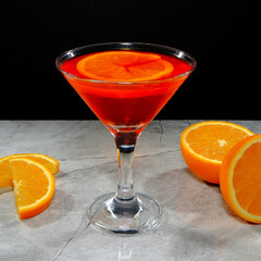 Vibrant orange cocktail with fresh slices on a modern gray surface closeup view
