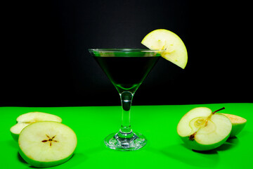 Sophisticated green apple martini with fresh slices on vibrant green closeup shot