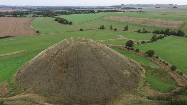 Silbury Hill prehistoric man made chalk and clay mound near Avebury stone circle henge, England. 39m high. Earliest dates from 2400BC. View from SW. Video fly in down