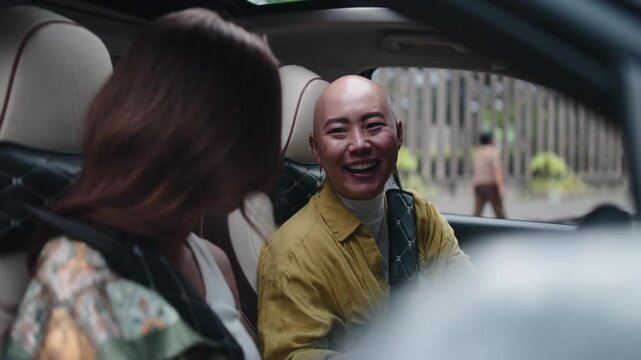 Two cheerful asian women talking in a car
