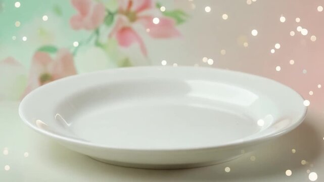 A white, empty plate sits centered, with blurred floral background and glowing bokeh lights