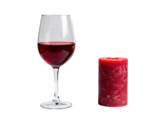 Glass of red wine next to a burning red candle,white background.