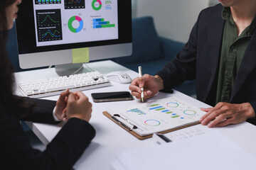 Business professionals analyzing data charts at office meeting