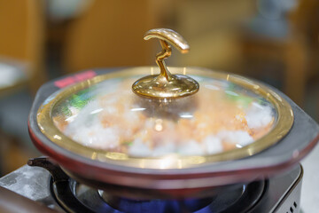 Woman tourist eating Sichuan Fish with Pickled Mustard Greens or Suan Cai Yu in restaurant. Popular foods for tourist eating in Chengdu, Chongqing and China. Chinese Asia and Sichuan foods concept