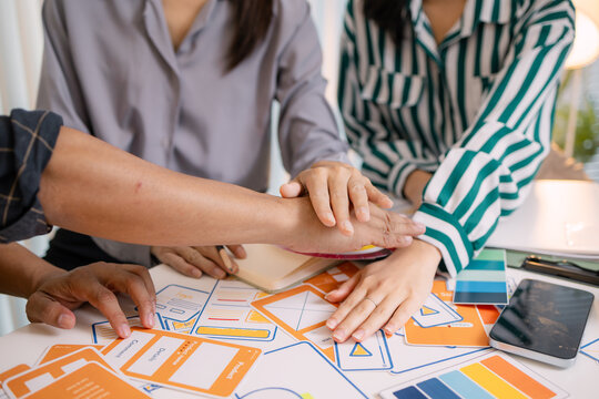 Designers having a UX/UI planning meeting to refine mobile app layouts and user flow. They collaborate closely to create functional and visually appealing interface solutions. - Powered by Adobe