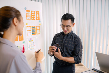 UX/UI designers collaborating during a creative workshop to test interface ideas and exchange feedback for app development, emphasizing teamwork and innovative design thinking.