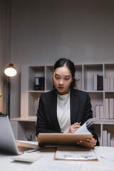 Asian businesswoman analyzing financial data working late