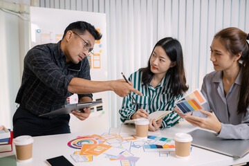A tense business meeting where a team discusses design problems and project challenges. The man tries to explain solutions while one team member looks stressed, showing workplace pressure and teamwork