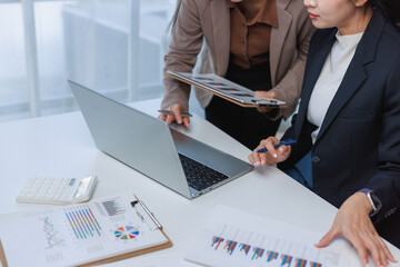 Businesswomen collaborating on laptop analyzing financial data
