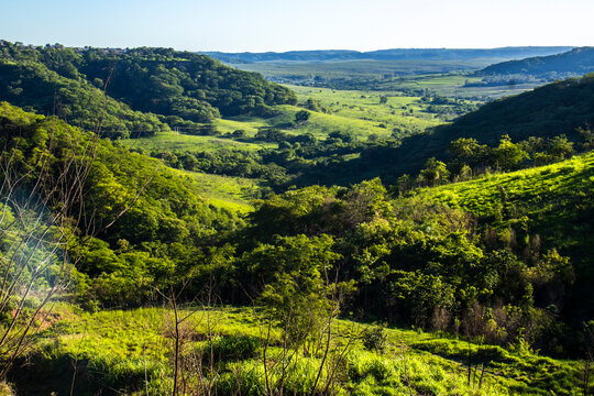 Stunning cliff formation in a lush green valley in Sao Paulo state. A landmark representing the region unique geology, farm pastures and the beauty of the Atlantic Forest biome