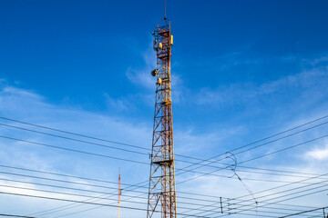 Telecommunication tower with antennas against a blue sky. Symbol of global connectivity, mobile networks, 5G technology, and wireless communication infrastructure for the digital age.