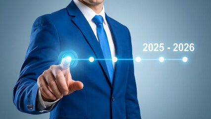Businessman in blue suit touching futuristic glowing interface setting goals for the important fiscal period of 2025 to 2026