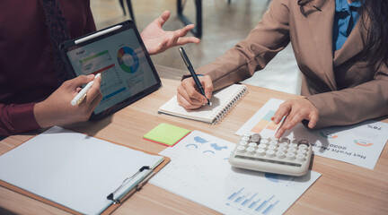 Business Strategy Session: Two professionals are engaged in a dynamic strategy session, collaborating over data visualizations and meticulously analyzing figures.