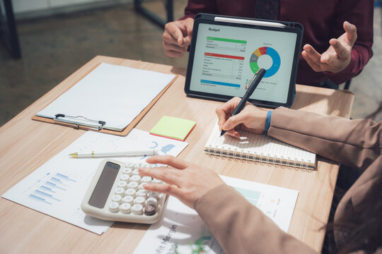 Business Analysis Meeting: Two business associates collaborate on financial analysis, examining data and insights. Capturing the process of strategy and calculation in action - Powered by Adobe