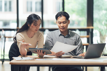 Collaborative workplace : Two coworkers, absorbed in discussion, working together on project, analyzing data and information, a partnership driven by common goal.