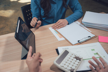 Collaboration and Strategy: Two individuals engaged in a dynamic meeting, engrossed in a discussion centered on data analysis and strategic planning using a tablet.
