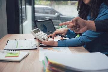 Financial Collaboration: Two professionals engage in a focused discussion, analyzing data and crunching numbers to achieve financial objectives, with teamwork and expertise.