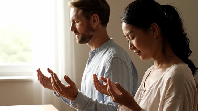 Serene Multiracial Couple Sharing a Peaceful Moment of Prayer and Meditation in Soft Sunlight