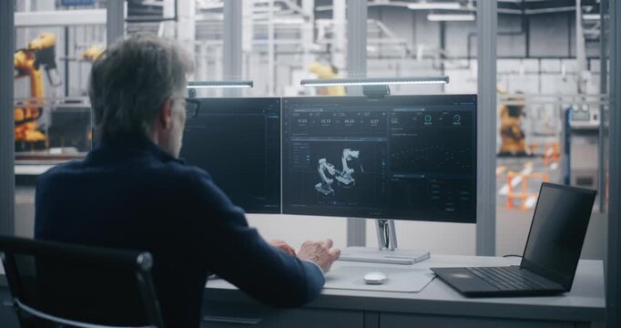 Experienced Manager Performs Remote Maintenance and Diagnosis of Industrial Equipment Using Dual Screen Workstation in Modern Data Center. Concept of Predictive Maintenance and Expert Control.