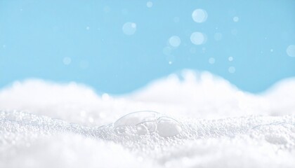Close-up of white soap suds with bubbles against a light blue backdrop