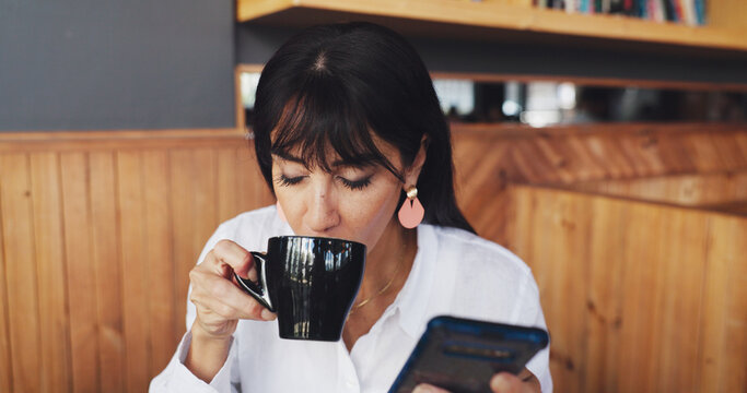 Business woman, phone and drink in coffee shop for break, social media and remote work. Mature freelancer, research and tech with cup for warm beverage, latte or espresso in cafe or restaurant - Powered by Adobe