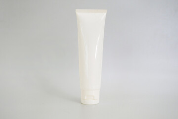 A cosmetic white tube mockup for cream or sunscreen. A plastic tube isolated on a gray background