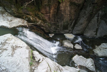 岩壁の仏像と流れ落ちる小川の風景