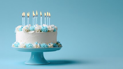 Elegant birthday cake with blue accents and lit candles