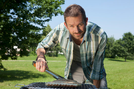 Person grilling outdoors in park on sunny day in Munich