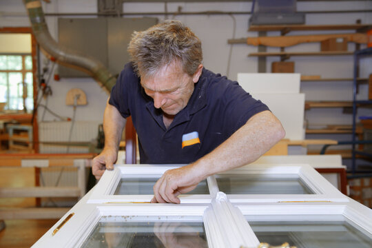 Carpenter repairing a window frame in workshop in Upper Bavaria