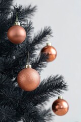 black christmas tree with copper-colored ornaments, close-up, on a white background.