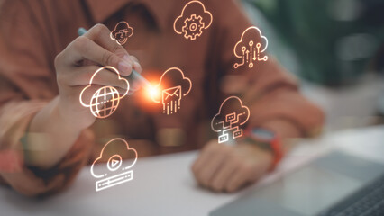 Business person hand using stylus pen touching virtual cloud computing icons. Concept of technology, data storage, global network connection, and digital transformation.