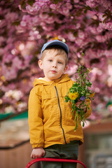 Young boy allergic enjoying after treatment from seasonal allergy at spring. Portrait of happy guy smiling in front of blooming tree at springtime. Spring allergy concept.