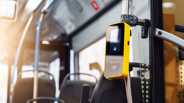 A contactless payment device is seen on a bus in urban transport, highlighting modern payment methods for riders.