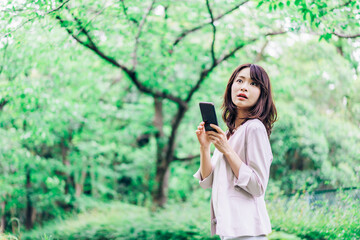 外でスマホを使うビジネスウーマン