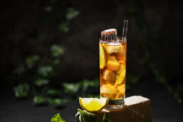 Glass of alcohol Long Island iced tea on dark background
