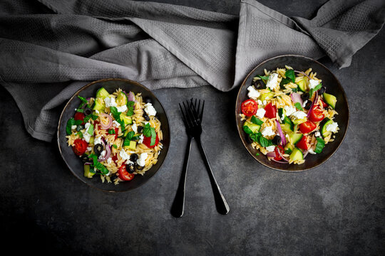 Mediterranean orzo salad with feta and olives served in bowls overhead