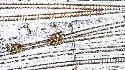 Railway lines, train tracks covered with snow aerial drone view, railway in the Netherlands in winter, transport disruption due to winter weather problems and heavy snow